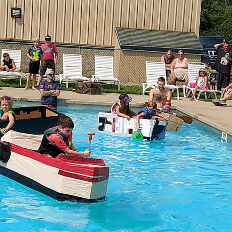 children playing boat races in a pool at Sparrow Pond Family Campground
