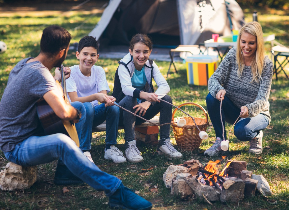 family making smores by tent